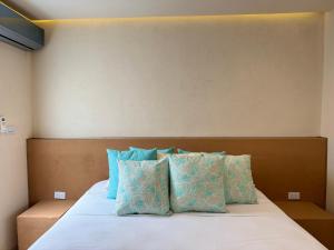 ein Schlafzimmer mit einem Bett mit blauen Kissen in der Unterkunft Techos Azules in Taganga