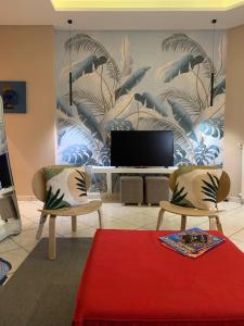 a living room with two chairs and a television at Pompei Duplex Apartment Deluxe in Boscoreale