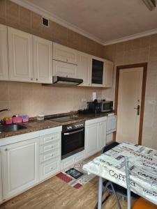 a kitchen with white cabinets and a table and a table and a table at Casa da Cabreira in Nigrán