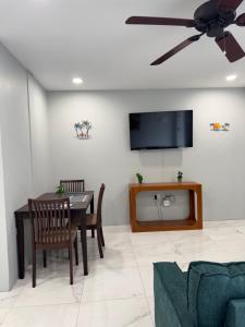 a living room with a dining room table and a ceiling fan at Dalleos Getaway in Tacarigua +9 photos
