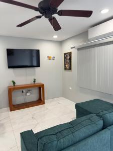 a living room with a couch and a ceiling fan at Dalleos Getaway in Tacarigua