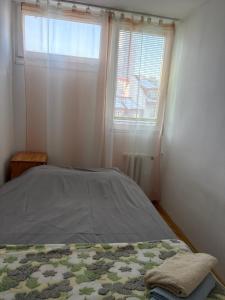 a bed in a bedroom with a window and a bedspread at Zakątek in Warsaw +2 photos