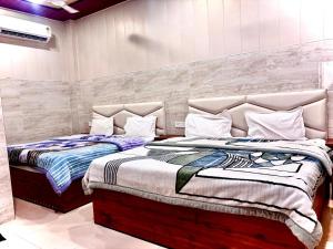 two beds sitting next to each other in a bedroom at Shri Murli Manohar Dham Hotel Vrindavan in Chhatikara