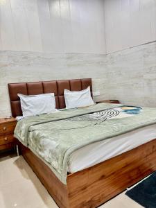 a bedroom with a large bed with a wooden frame at Shri Murli Manohar Dham Hotel Vrindavan in Chhatikara