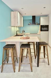 eine Küche mit einem Holztisch und zwei Hockern in der Unterkunft Chez Léon in Brugelette