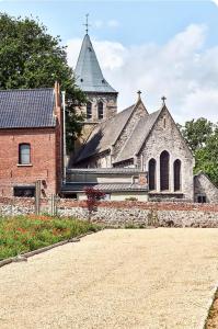 eine alte Kirche mit Turm und ein Backsteingebäude in der Unterkunft Chez Léon in Brugelette
