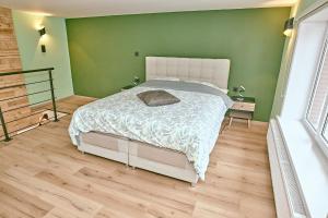 ein Schlafzimmer mit einem Bett und einer grünen Wand in der Unterkunft Chez Léon in Brugelette