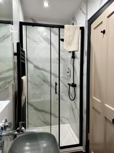 a bathroom with a shower with a glass door at The Pines Guest House in Elgin