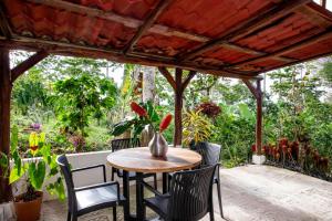 a table and chairs on a patio with a pergola at Casa Cúrcuma in Turrialba +1 photo
