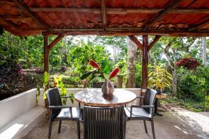 a table and chairs on a porch with a view of the forest at Casa Cúrcuma in Turrialba