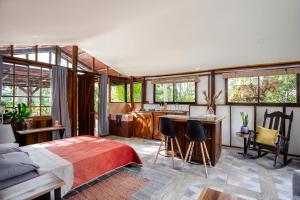 a bedroom with a bed and a kitchen at Casa Cúrcuma in Turrialba