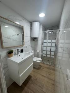 a white bathroom with a sink and a toilet at Vacaciones en familia Ap Portitxol en Xàbia in Platja de l'Arenal +19 photos