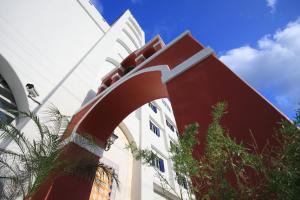 a white building with a red archway in front of it at Hotel Bayview in Dahan