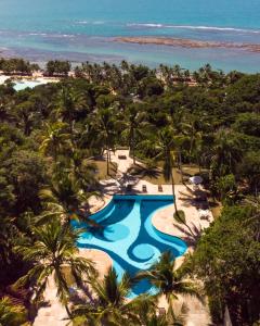an aerial view of a swimming pool and the beach at Pousada Vila do Beco in Arraial d'Ajuda