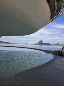 a view of the water from under a building at Conforto e Lazer a 50m da Praia in Niterói