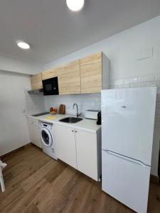 a kitchen with a white refrigerator and a dishwasher at Vacaciones en familia Ap Portitxol en Xàbia in Platja de l'Arenal