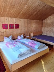 a bedroom with two beds in a wooden room at Ferienhof Muxel in Großdorf