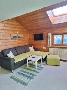 a living room with a couch and a table at Ferienhof Muxel in Großdorf