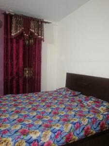 a bed with a colorful quilt on it in a bedroom at Mall City Hotel Lahore in Lahore