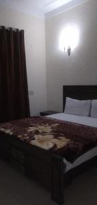 a bedroom with a bed in a room with a light at Mall City Hotel Lahore in Lahore