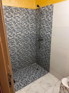 a bathroom with a shower with black and white tiles at Appartement chic in Tit Mellil +14 photos