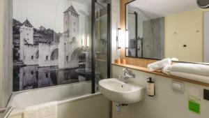a bathroom with a sink and a mirror at Campanile NATURE - Niort Est La Crèche in La Creche