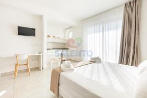 a white bedroom with a bed and a desk at Residence Stella del Mare in Torre Pali +33 photos