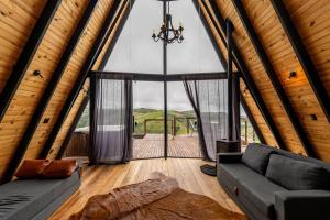 a living room with a large window and a couch at Canda Cabana com SPA e vista para Cachoeiras in Baependi