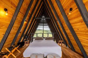 a bed in a room with a large window at Canda Cabana com SPA e vista para Cachoeiras in Baependi
