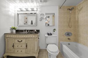 a bathroom with a sink and a toilet and a tub at The Pantages Suites in Toronto +42 photos
