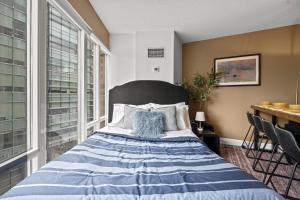 a bedroom with a bed with a large window at The Pantages Suites in Toronto