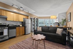 a living room with a couch and a kitchen at The Pantages Suites in Toronto