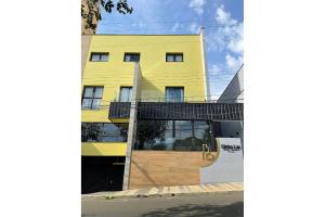a yellow building with a ramp in front of it at Globo Lar Studios in Limeira