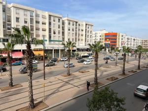 a city street with palm trees in front of buildings at Appartement chic in Tit Mellil