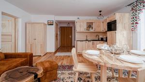 a kitchen and living room with a table and a couch at Apartament Białka J6 in Białka Tatrzańska