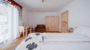 a bedroom with two beds and a table and a window at Apartament Białka J6 in Białka Tatrzańska