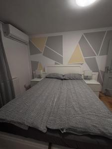 a bedroom with a bed with a geometric wall at Apartment Elize in Zagreb