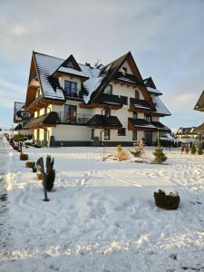 a large house in the snow in front at Apartament Białka J6 in Białka Tatrzańska