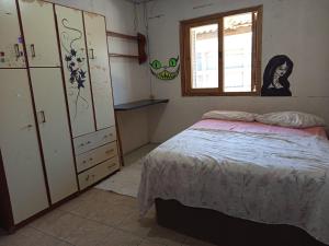 a bedroom with a bed and a window at Kitnet simples in Capão da Canoa