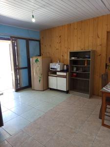 a kitchen with a refrigerator and a stove at Kitnet simples in Capão da Canoa