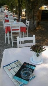 a table with white chairs and a book on a table at Tokalis Boutique Hotel & Spa in Nea Anchialos