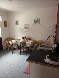 a kitchen with a table and chairs in a room at Přijďte pobejt in Benecko