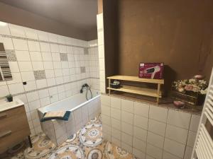 a bathroom with a tub and a tile floor at Přijďte pobejt in Benecko