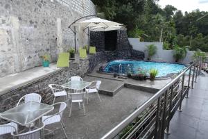 a patio with a table and chairs and a pool at Ayaana Boutique Hotel in Kandy