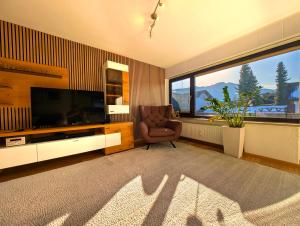 a living room with a chair and a large television at Ferienwohnung Alpenglut in Nesselwang