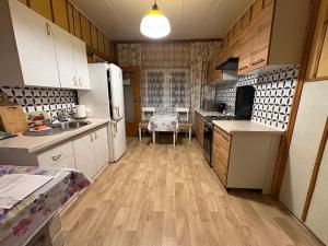 a kitchen with white appliances and wooden floors at Pod Dębem in Białowieża