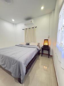 a bedroom with a bed and a lamp in it at Baan Lanta in Ko Po