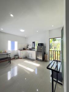 a large white kitchen with a stainless steel refrigerator at Baan Lanta in Ko Po +6 photos
