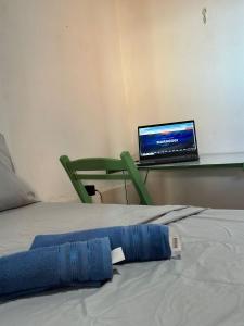 a bed in a room with a laptop on a table at CASA MARAGOGI 3 Quartos in Maragogi