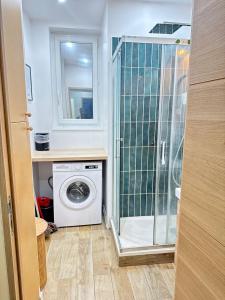 a bathroom with a washing machine and a mirror at Jupiter Paris in Champigny-sur-Marne